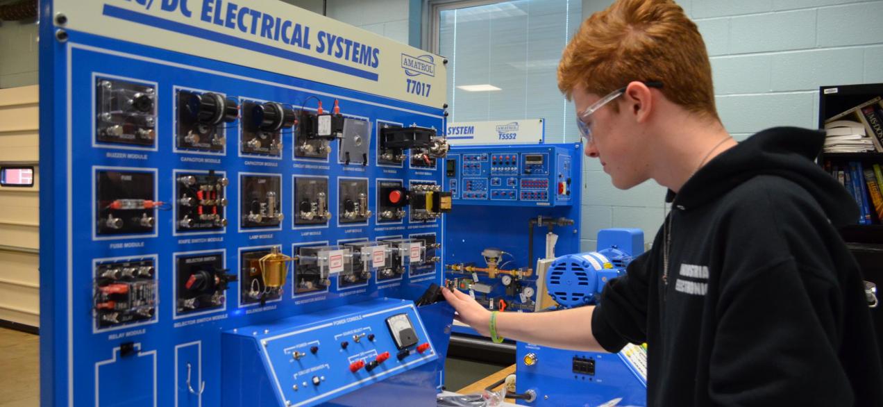 Image of student working on AC/DC Electrical Systems trainer