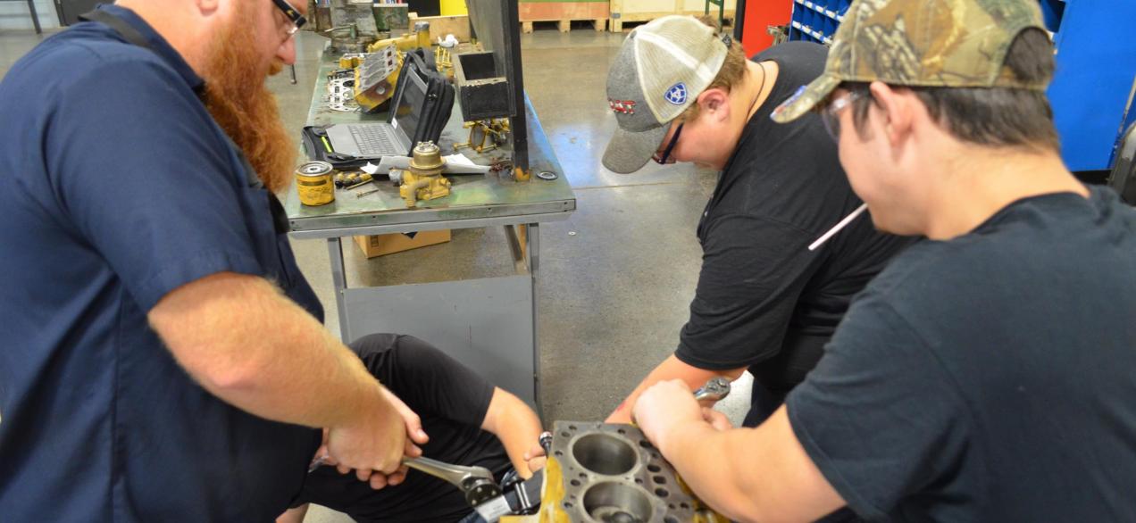 Image of a teacher and student working on a truck engine