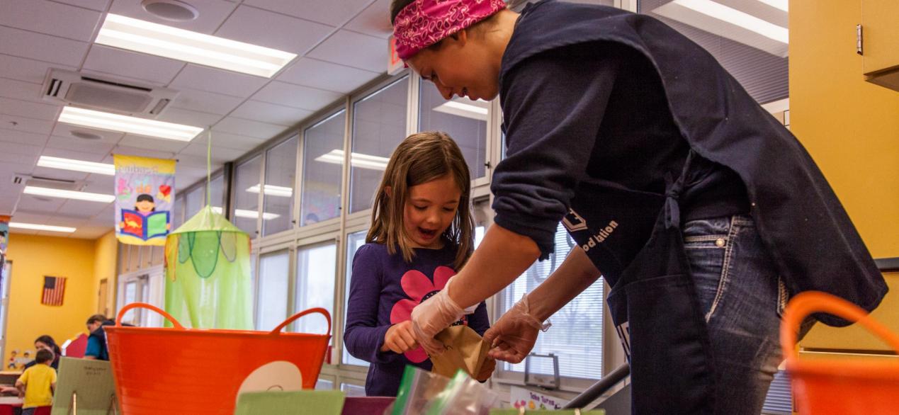 Image of a happy preschooler with student