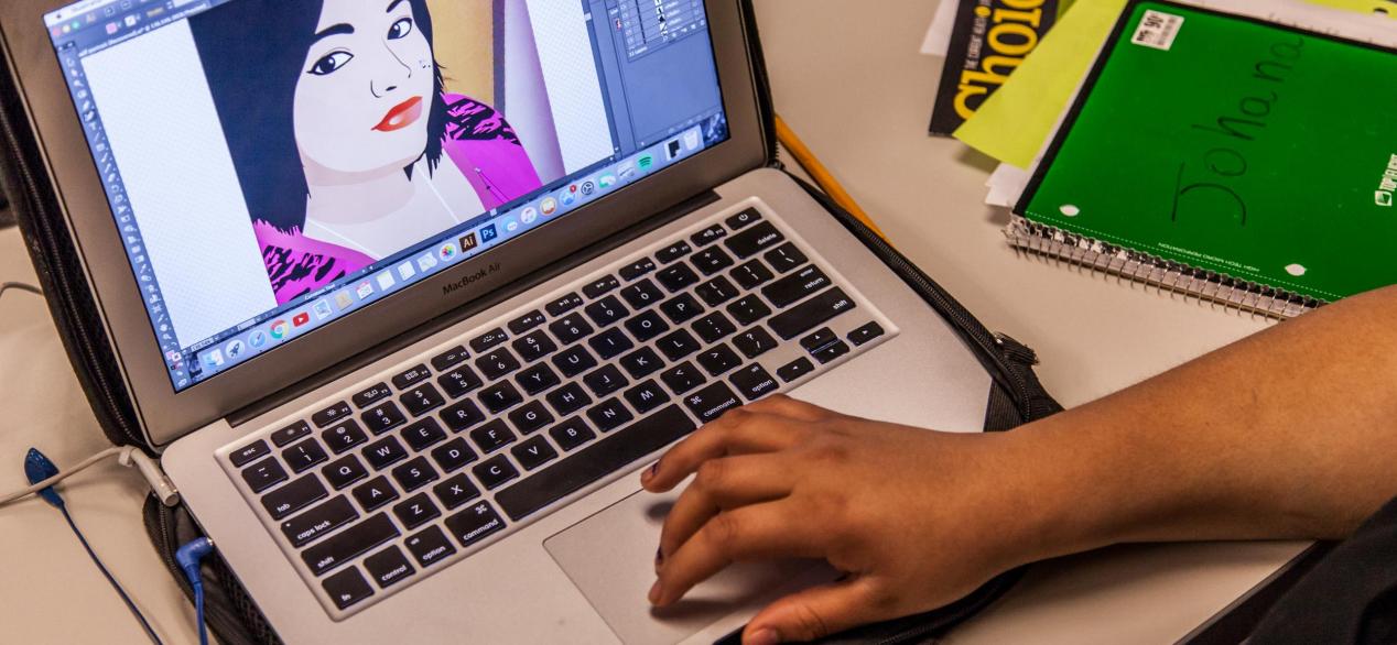 Image of student designing a cartoon image on a laptop 