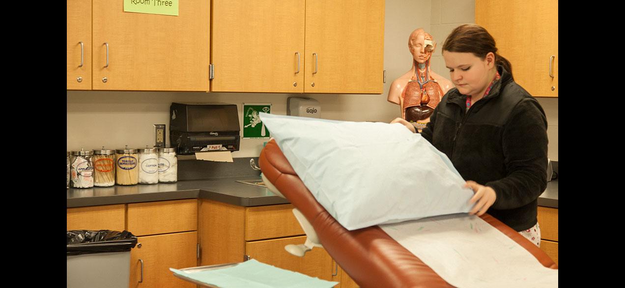 Student prepping doctors office for patient