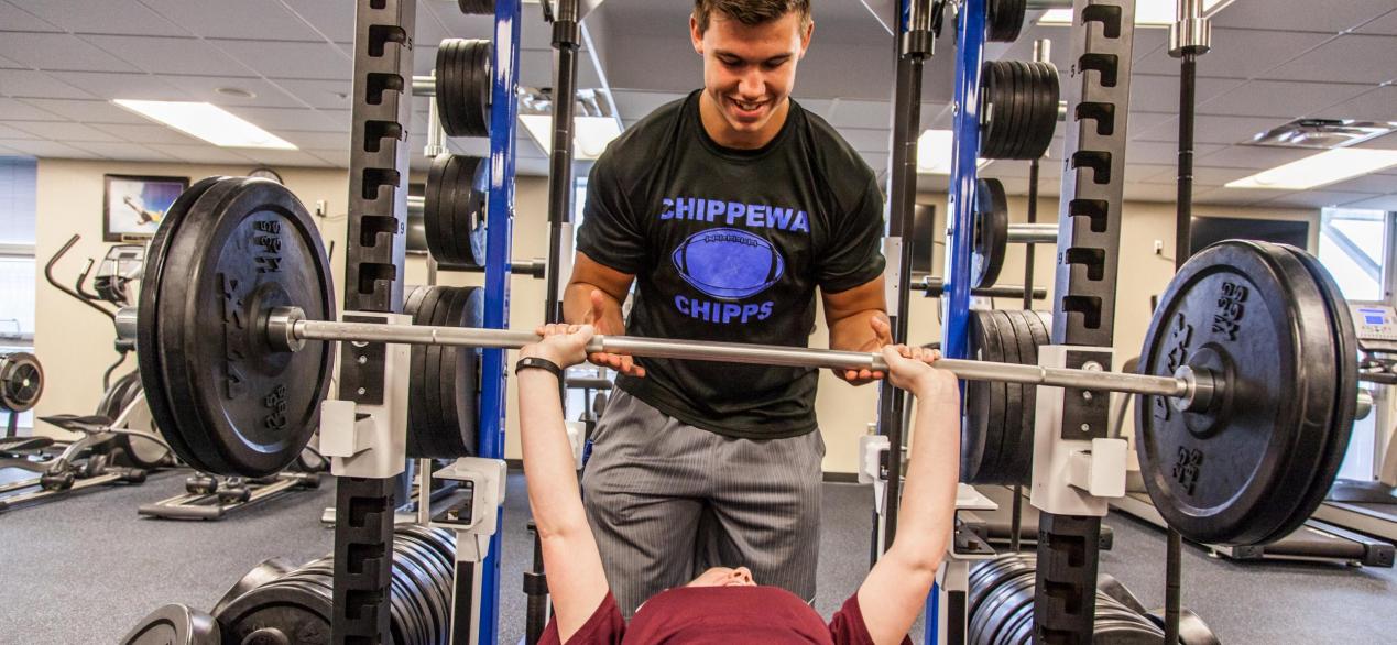 Image of student spotting/training in lifting weights 