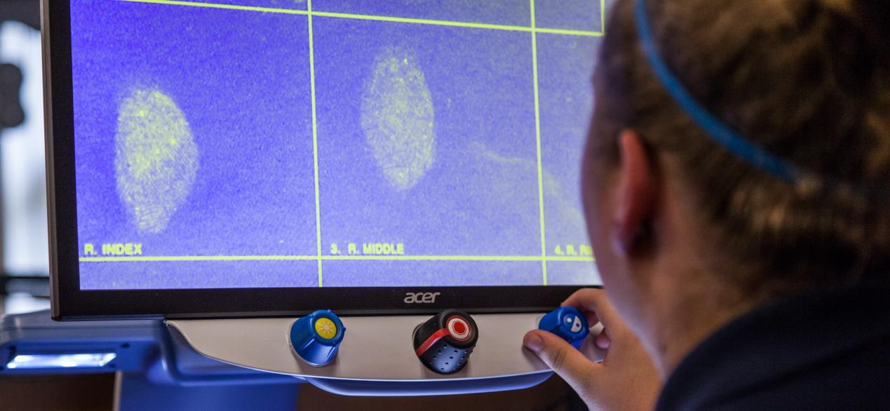 Image of students looking at fingerprints on a computer screen 