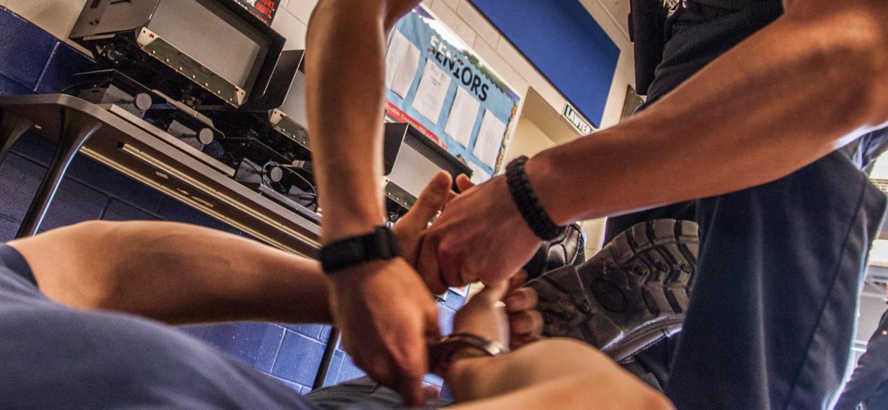 Image of student learns how to handcuff a suspect