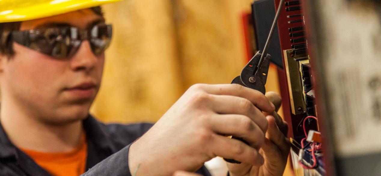 Image of student using tools to cut wires 