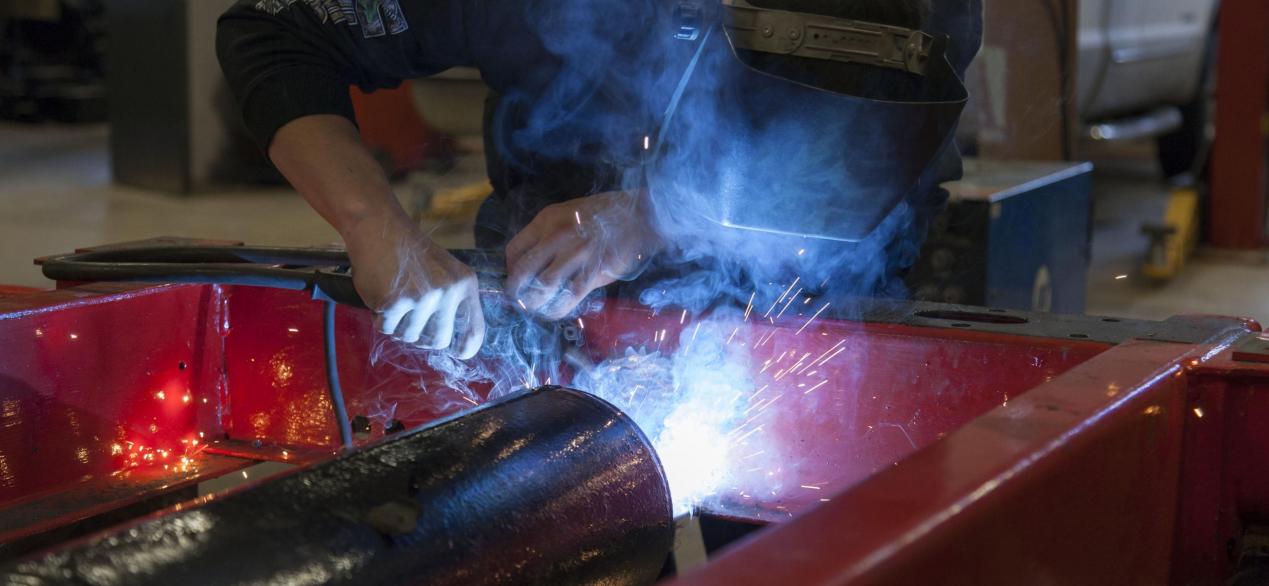 Image of student welding a truck frame