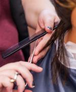 image of cosmetology student cutting a mannequin's hair