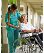 image of a nurse talking to an older man in a wheelchair