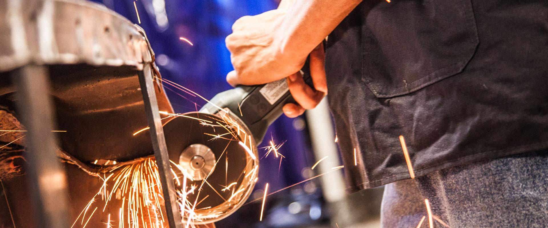 A metal grinder cutting a piece of metal