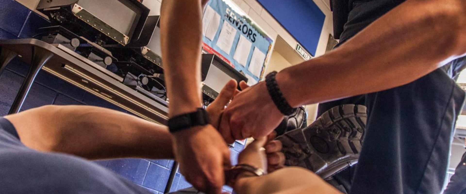 A student handcuffing another student