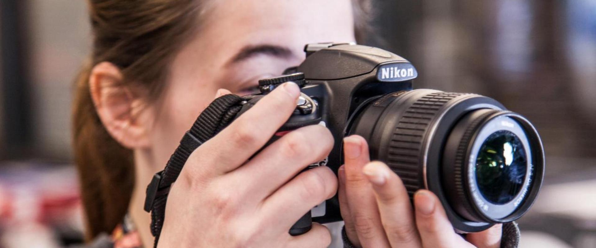 A closeup of a individual taking a photo with a Nikon camera