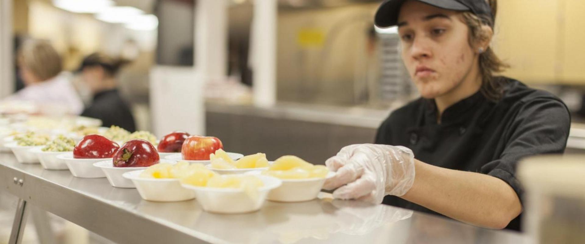 a cafeteria worker assembling food for easy grab and go type of service