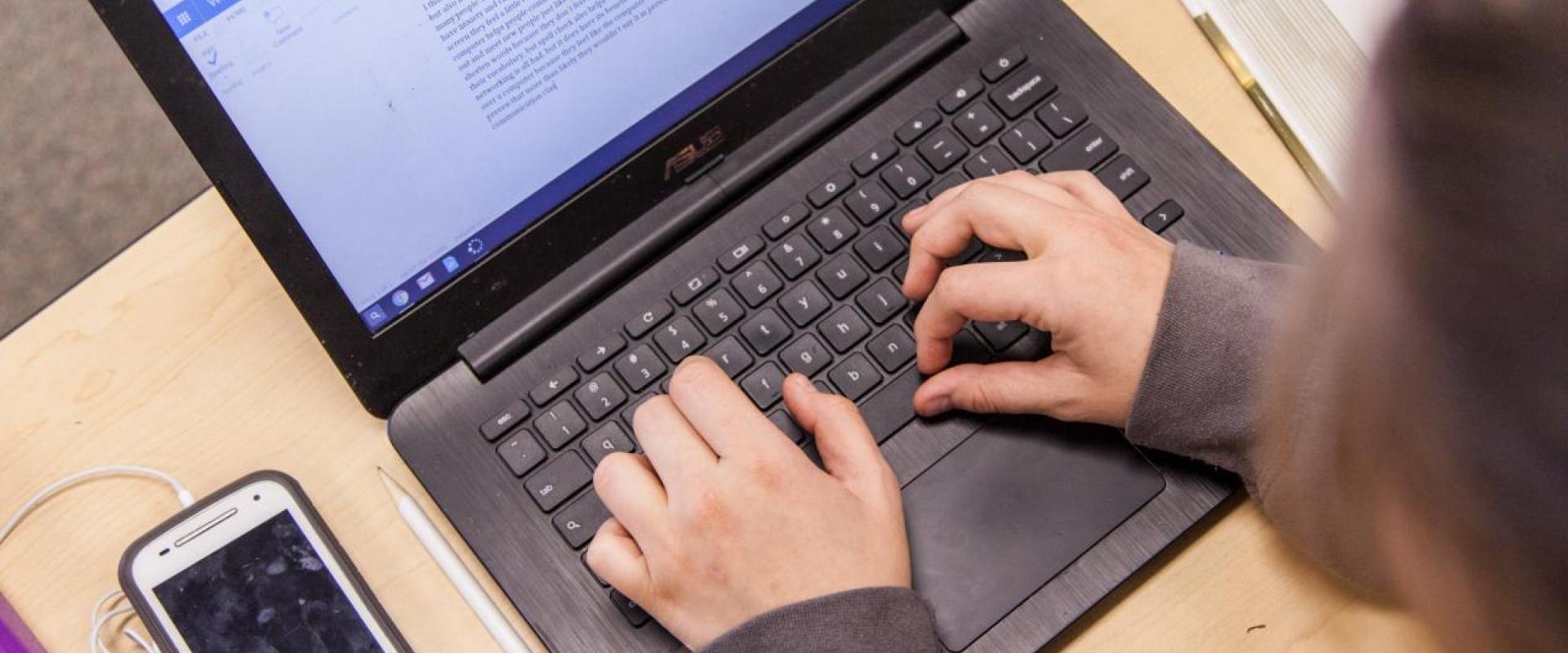Top down shot of a person typing at a desk. 