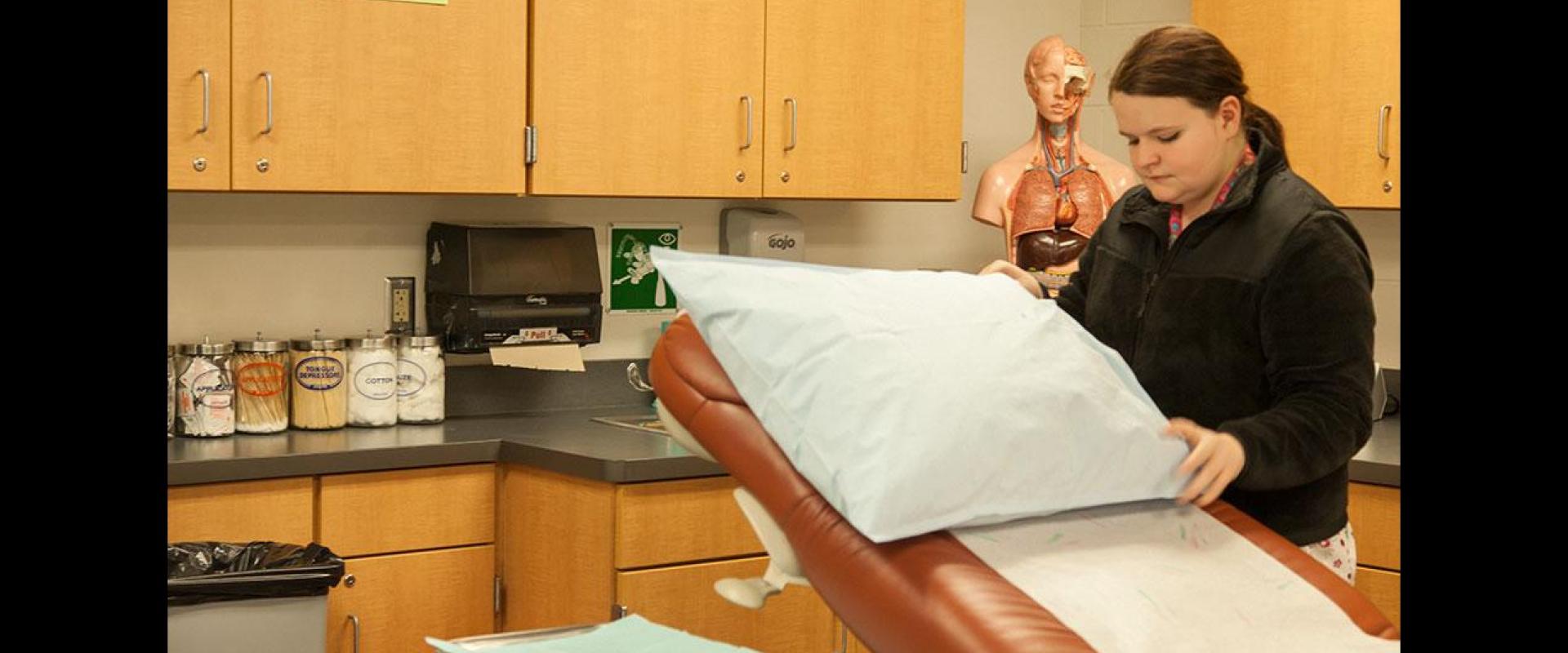 A nurse adjusting a pillow on a medical table