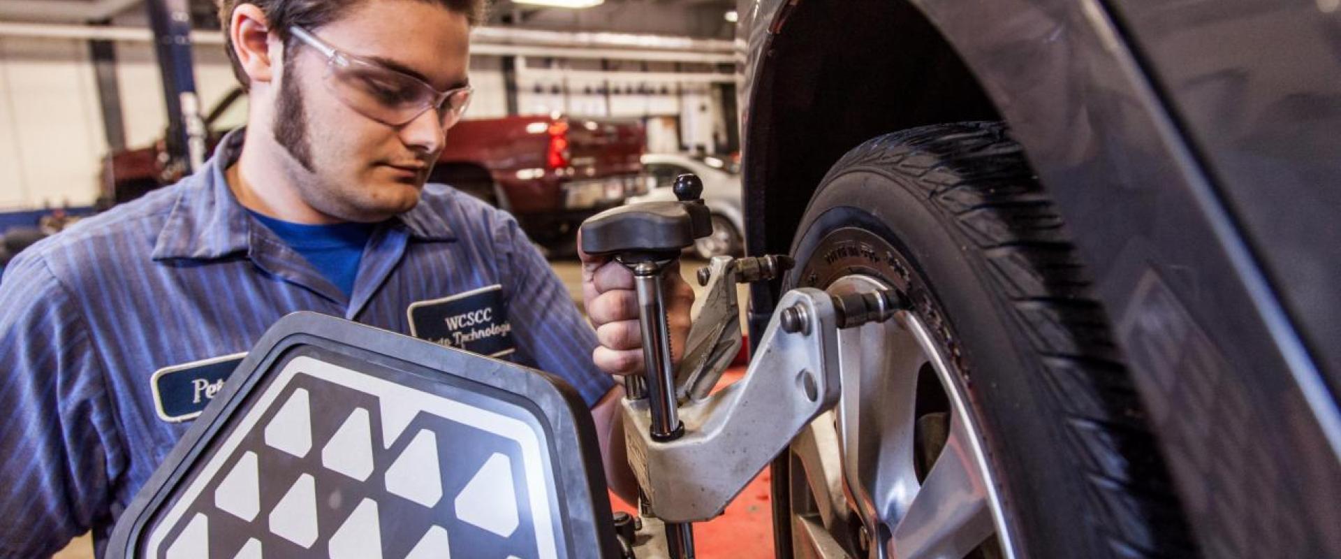 A mechanic working on a tire of a vehicle