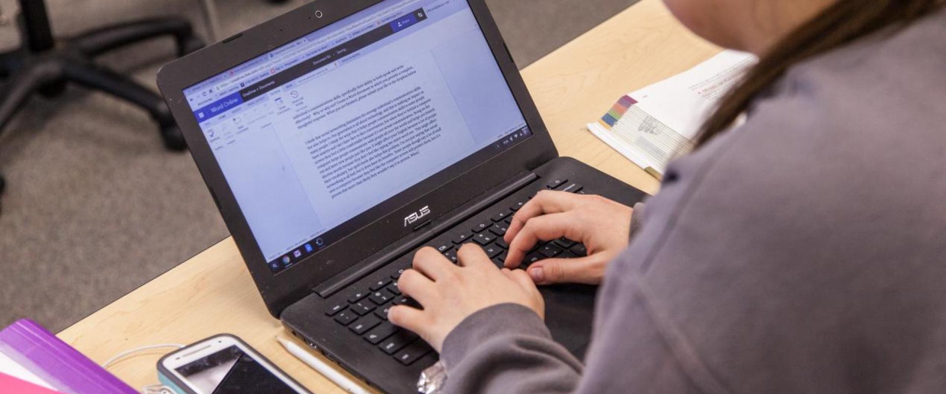An individual typing on a computer