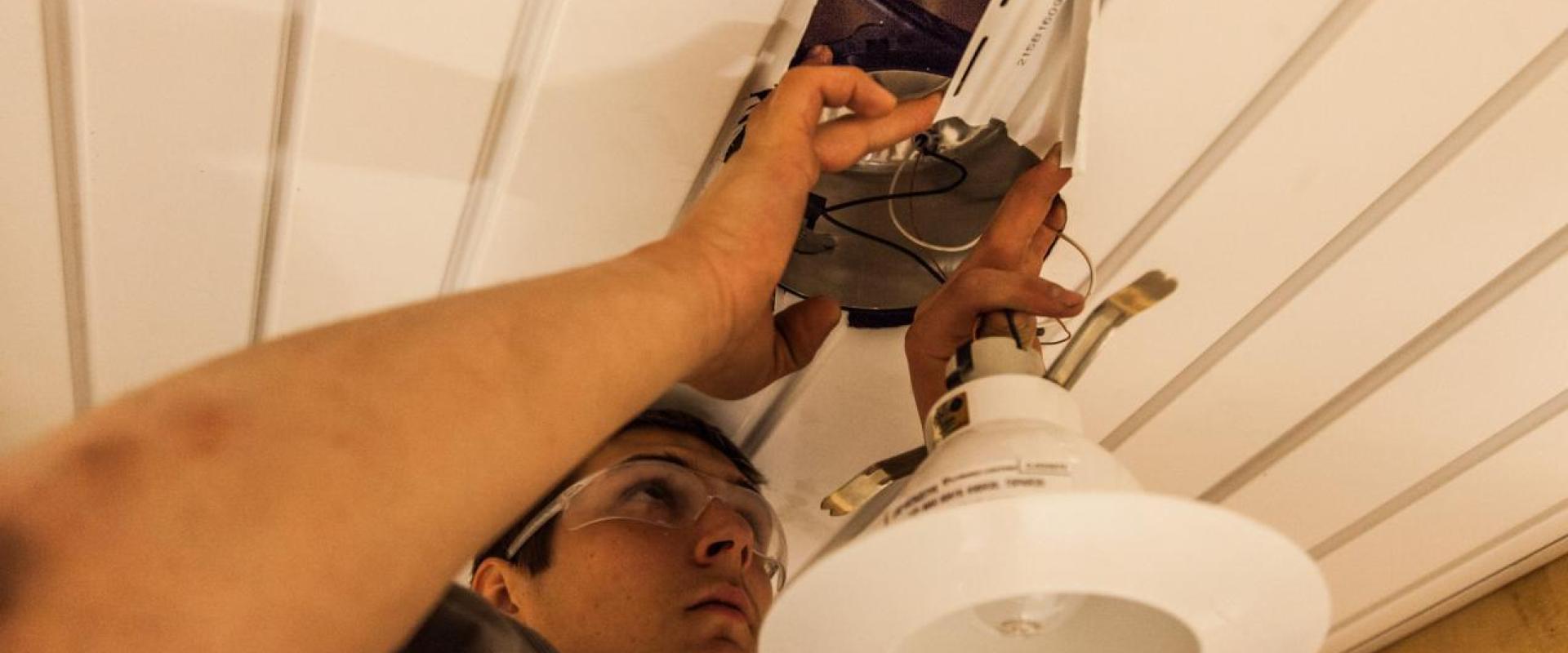 A student installing a lighting fixture