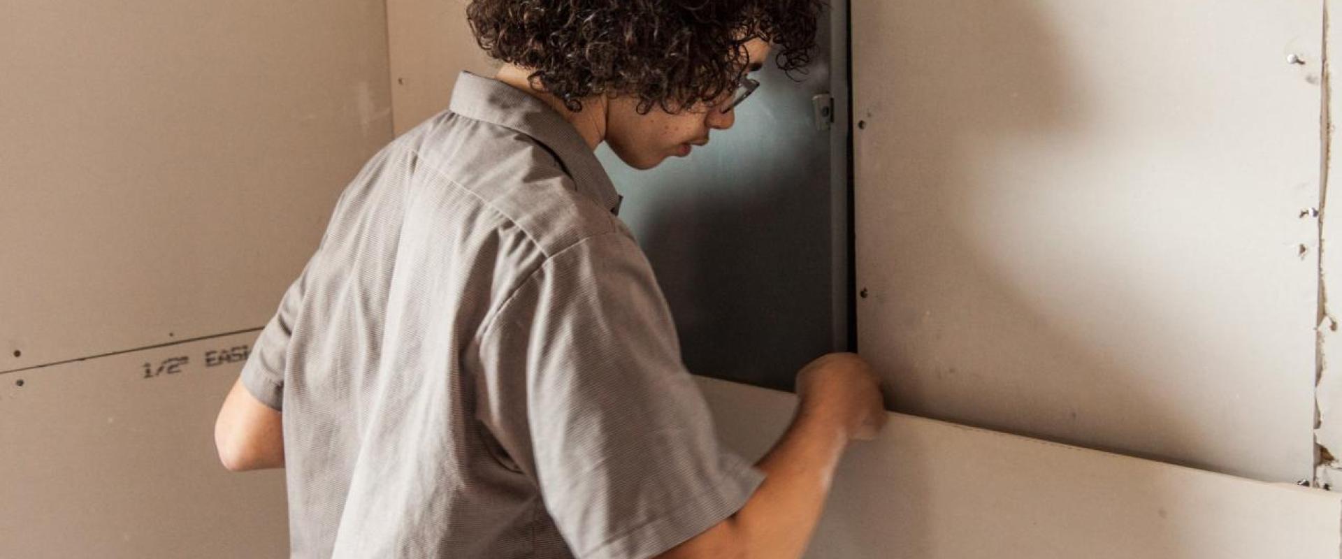 Student installing drywall