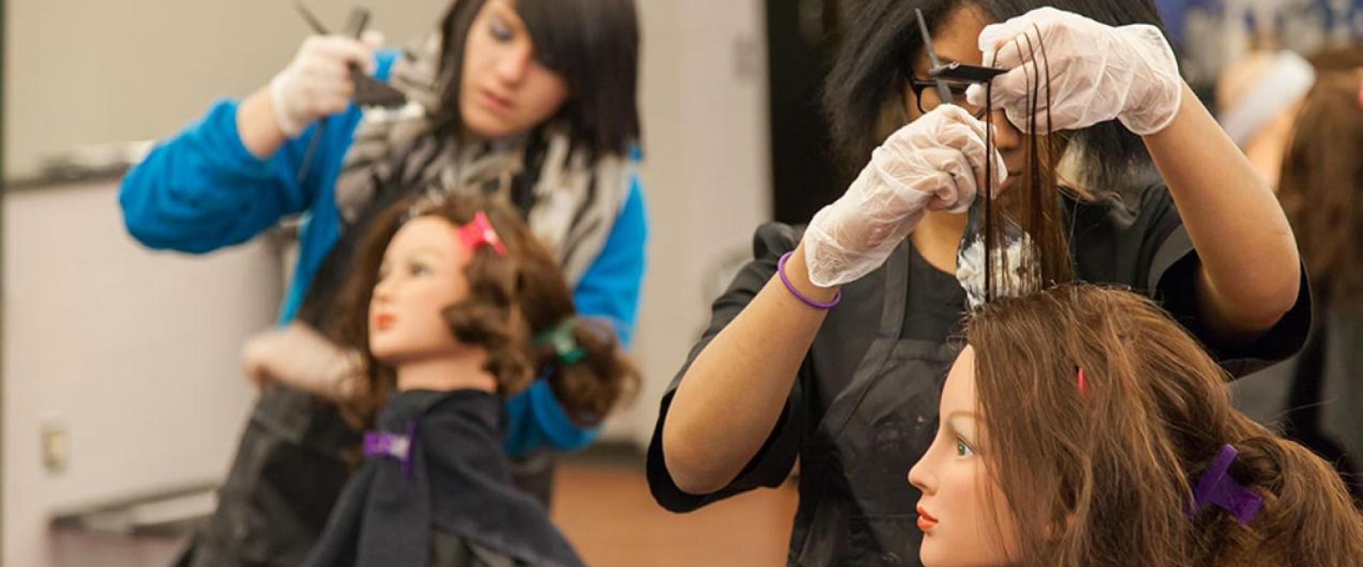 Two students applying bleach to a mannequin's hair