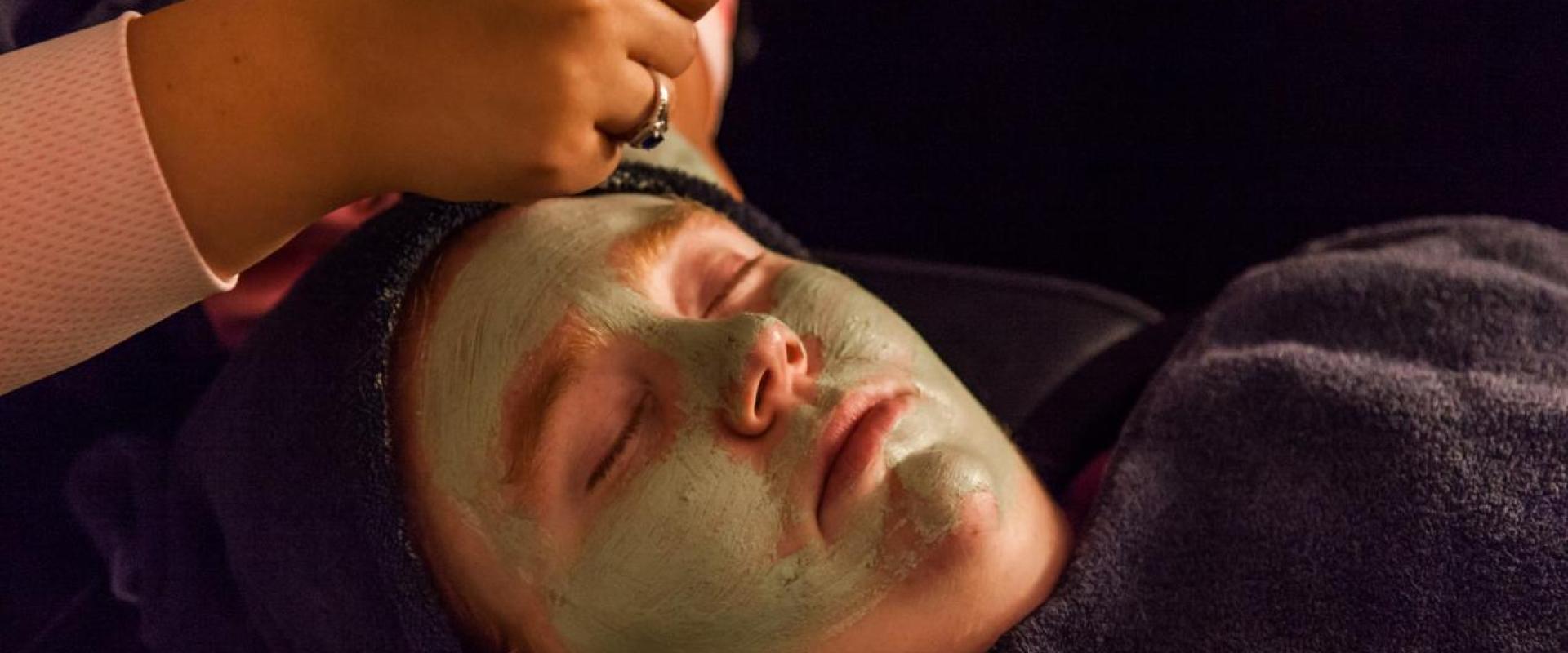 Student preforming a facial treatment to another student