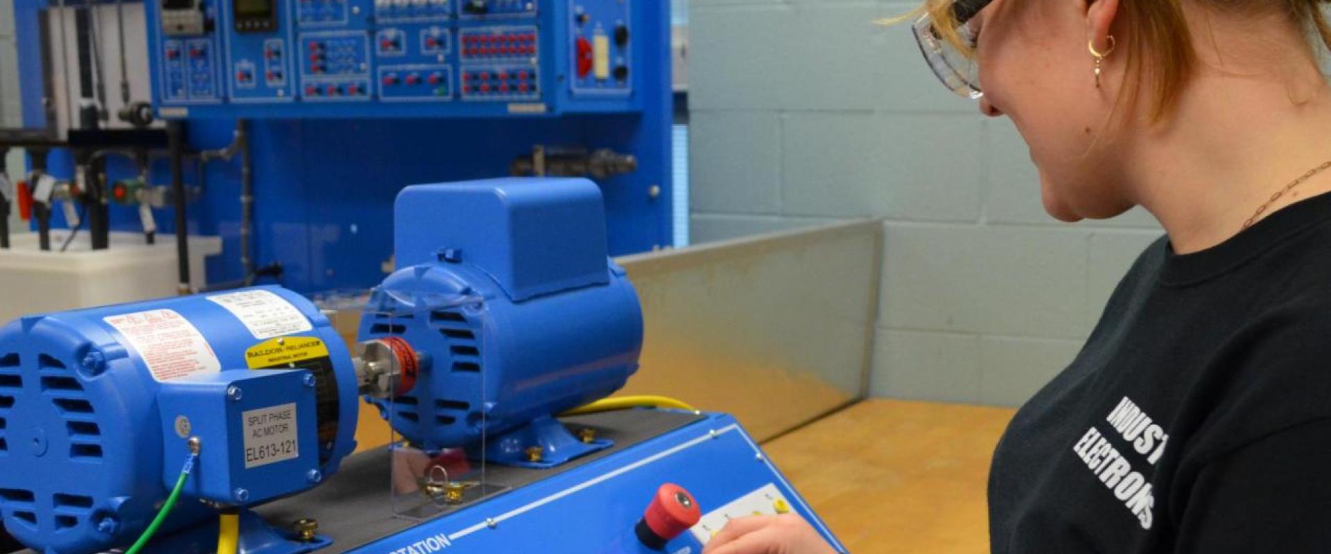 A student in front of an electronics machine