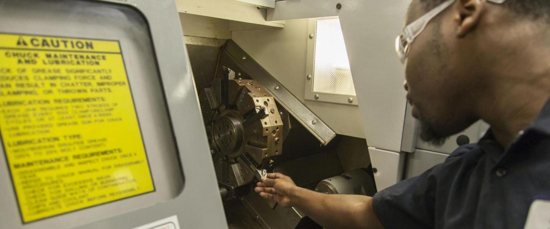 A man working at a machine lathe