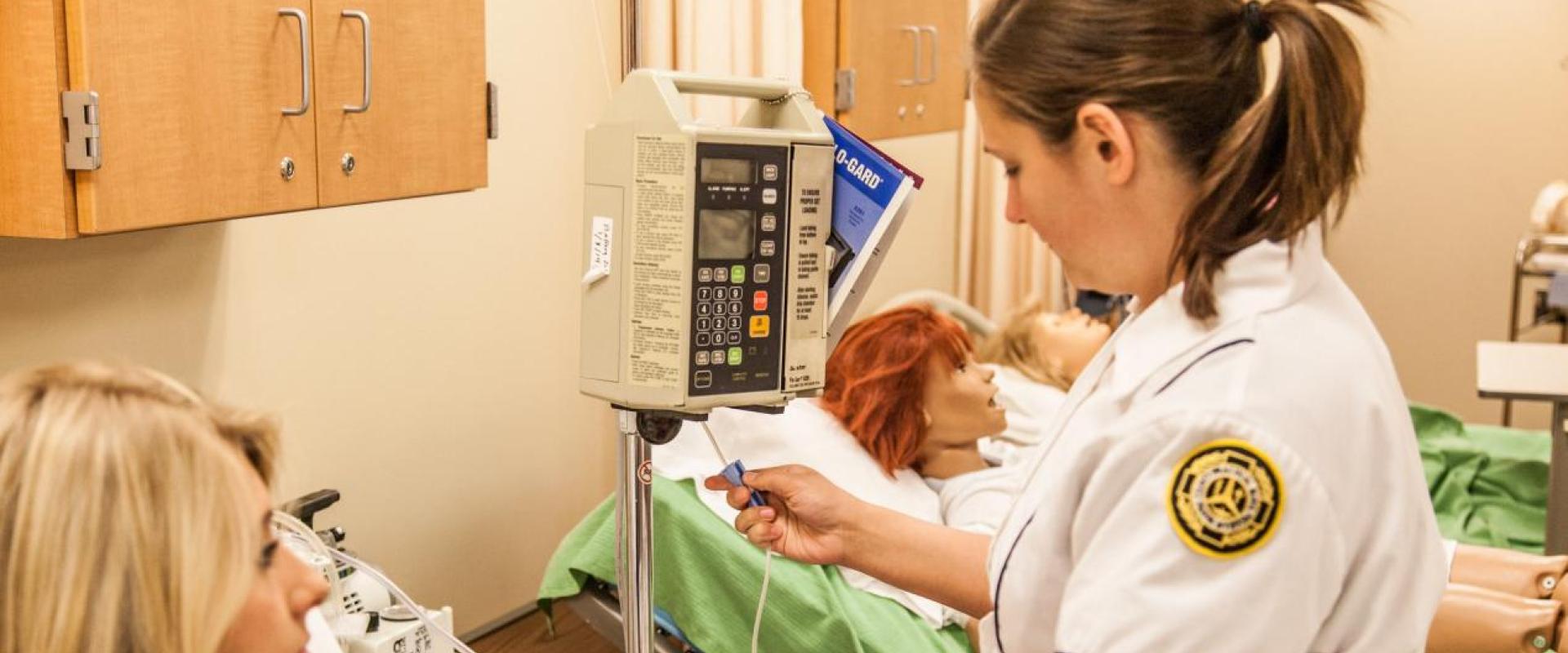 A nurse adjusting the clamp on an IV bag