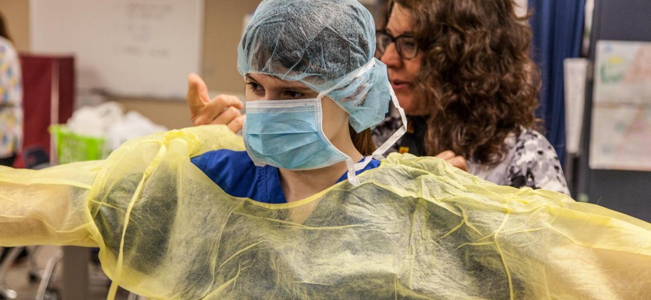 Image of student putting on personal protective equipment 