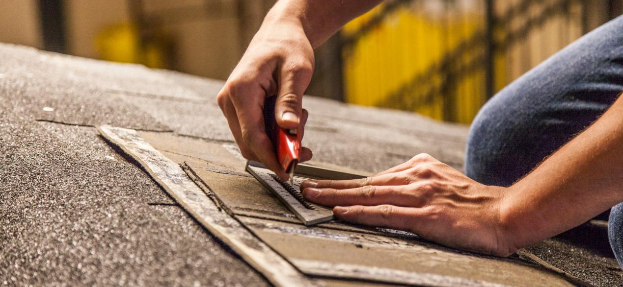 Image of student cutting roofing shingles