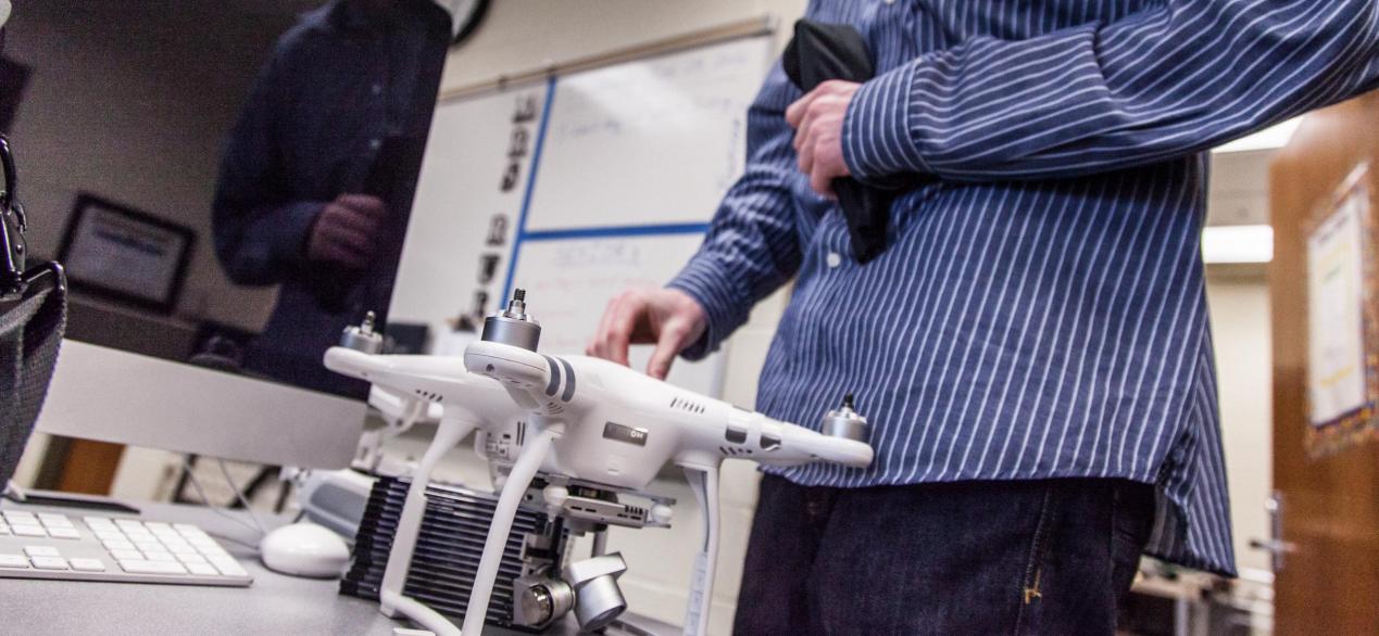 Image of a student working with a drone inside the classroom 