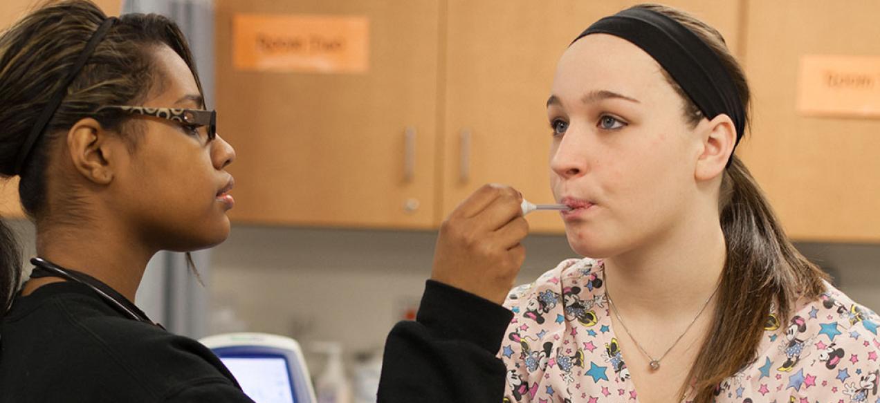 Girl takes temperature of classmate