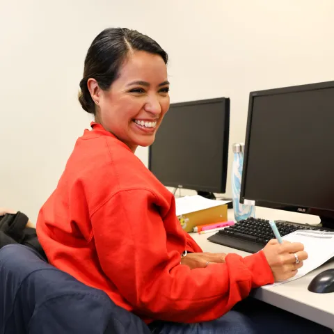 admin office student smiling taking notes