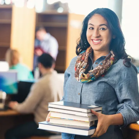 person holding books in a school