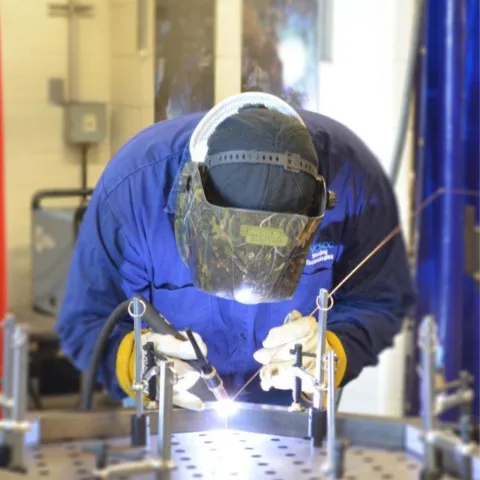 person welding with helmet on