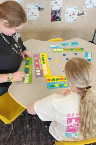 Two students sitting at a table working on an activity