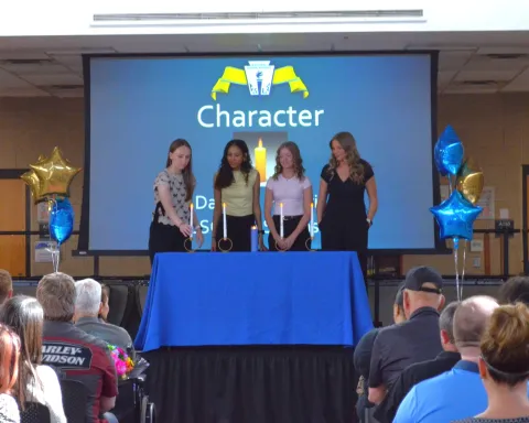 Four students light candles representing the four pillars of NHS