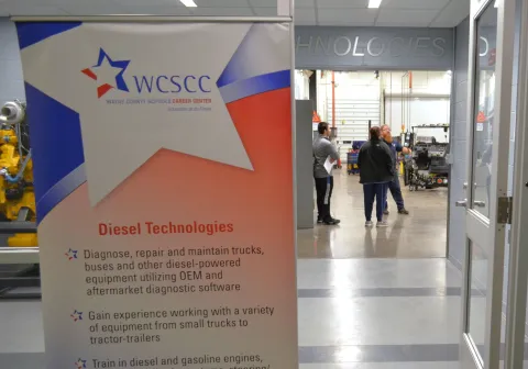 Teacher talks to student and parent at a previous Open House event