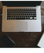 image of a laptop computer, notepad, and pen